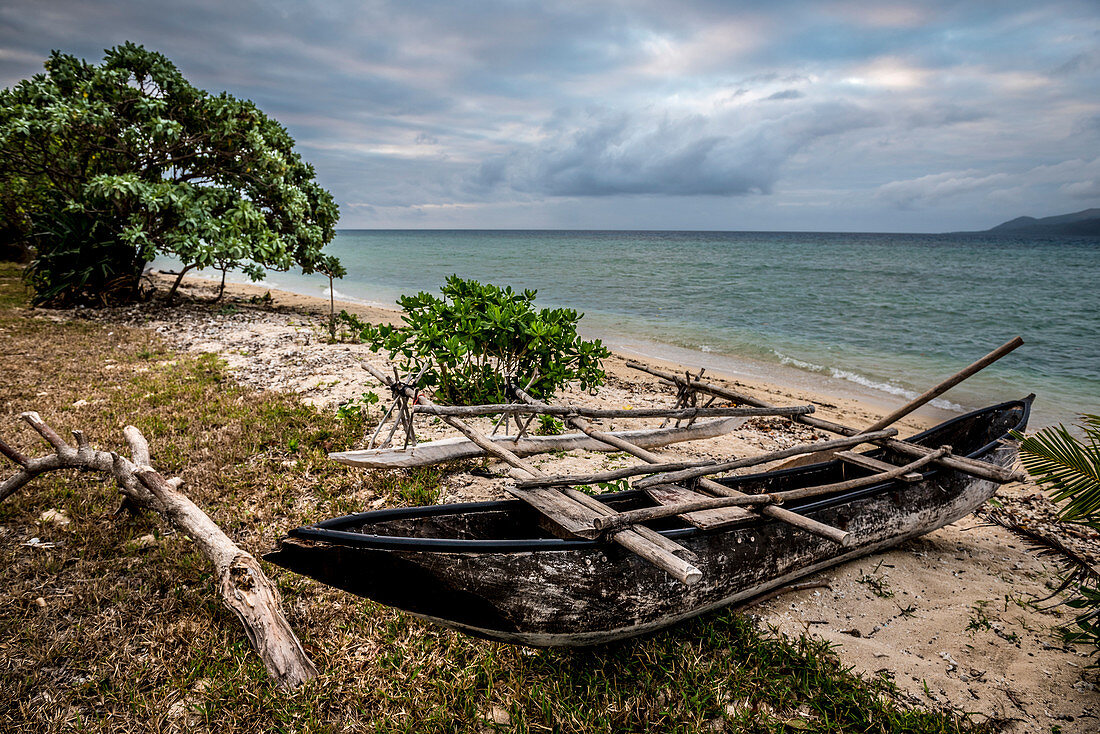 Dugout boat lies on a beach, Efate, Vanuatu, South Pacific, Oceania