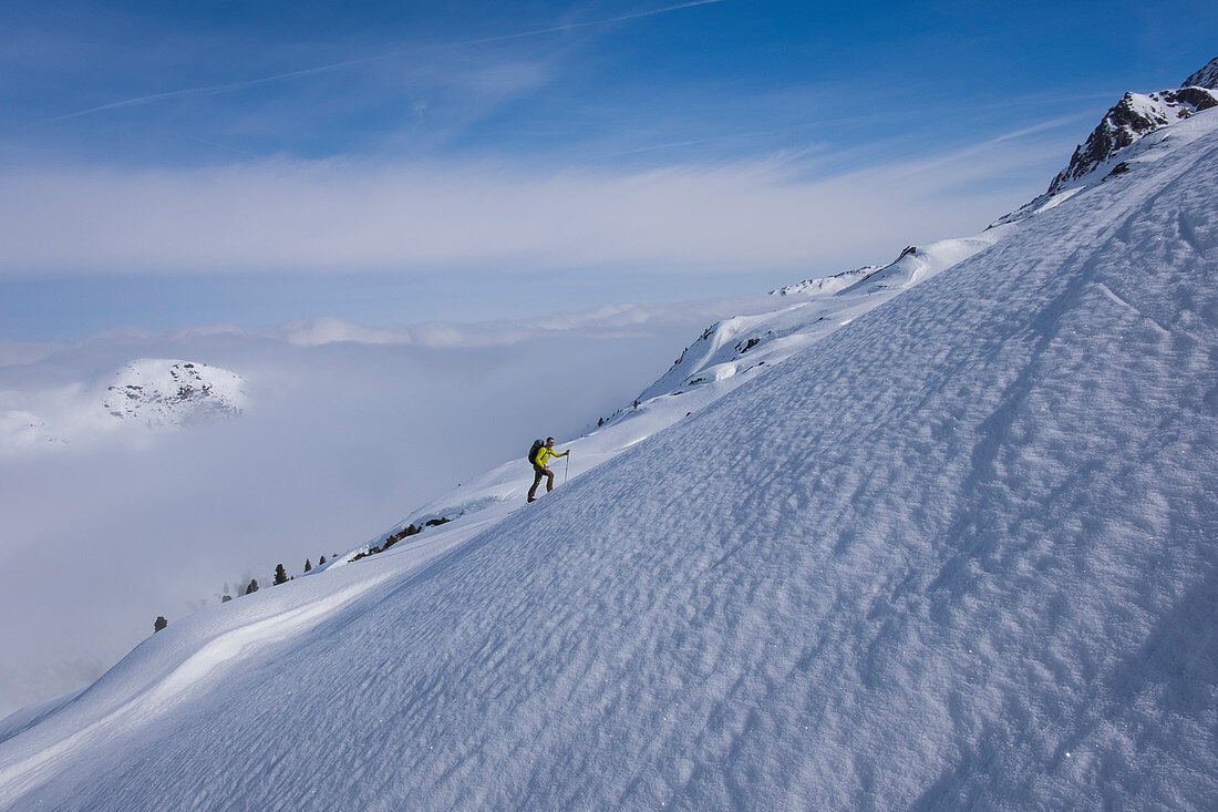 Skitourengeher im Gebirge der Kitzbüheler Alpen beim Aufstieg in steilem Schneefeld, Winter in Tirol, Österreich