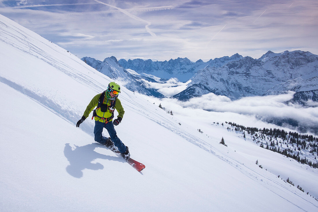 Snowboarder auf Splitboard im Tiefschnee bei der Abfahrt im Karwendel am Schafreiter, Tirol, Österreich