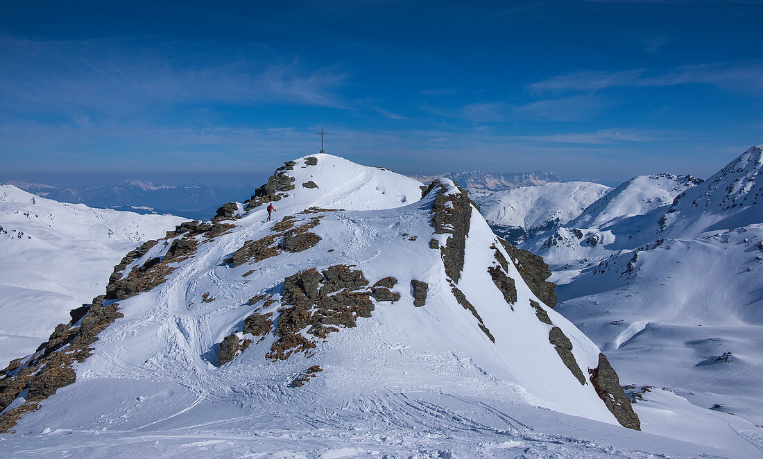 Skitourengeher im Gebirge der Kitzbüheler Alpen beim Aufstieg zum Gipfel des Tristkopf in der Sonne, Winter in Tirol, Österreich