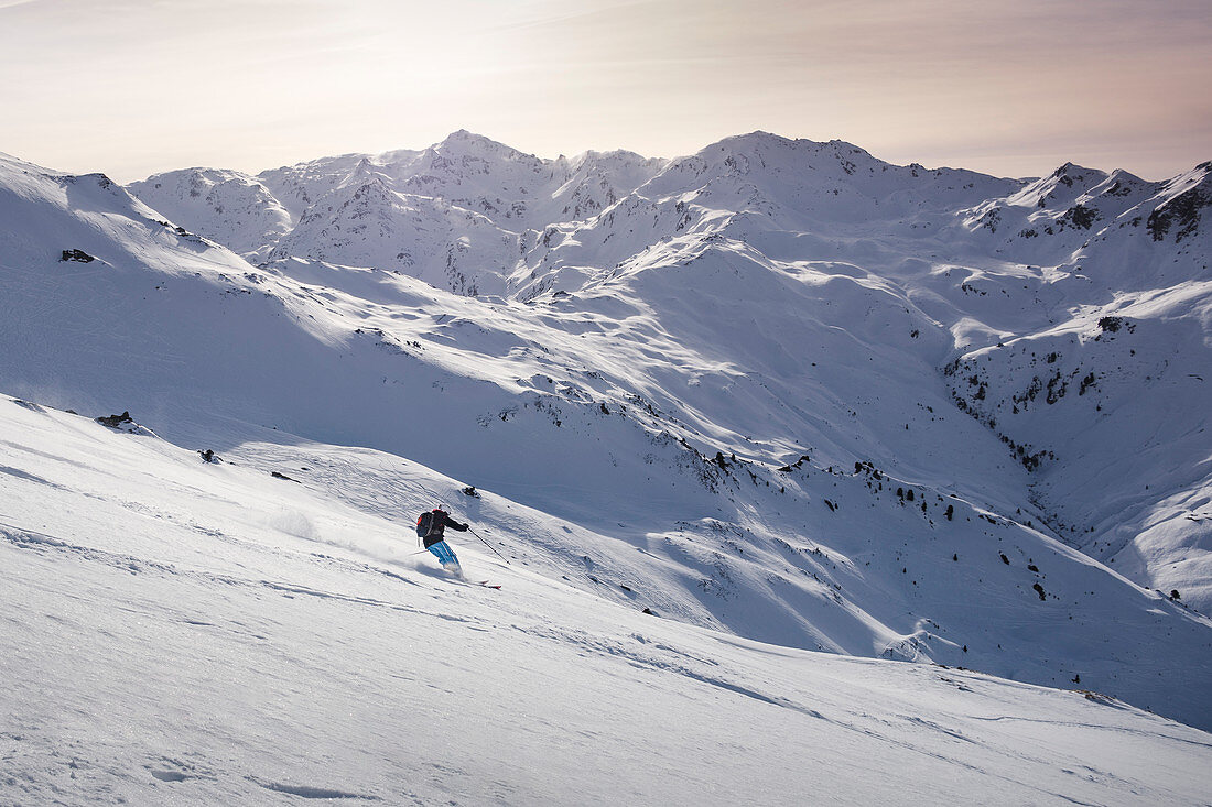 Skifahrer im Tiefschnee bei Sonnenuntergang in den Zillertaler Alpen, Hochfügen, Winter in Tirol, Österreich
