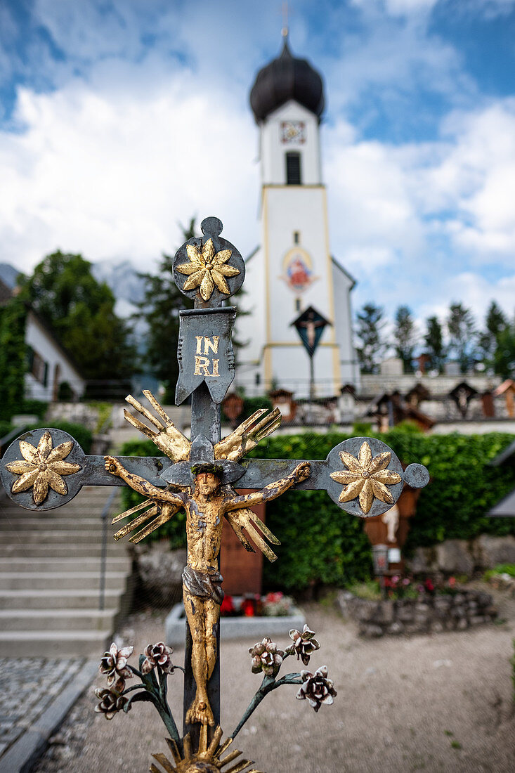 View of St. John the Baptist Church in Grainau, in the foreground a cross, Grainau, Bavaria, Germany, Europe