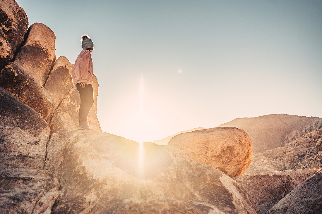 Woman hikes between rocks in Joshua Tree National Park, Los Angeles, California, USA, North America