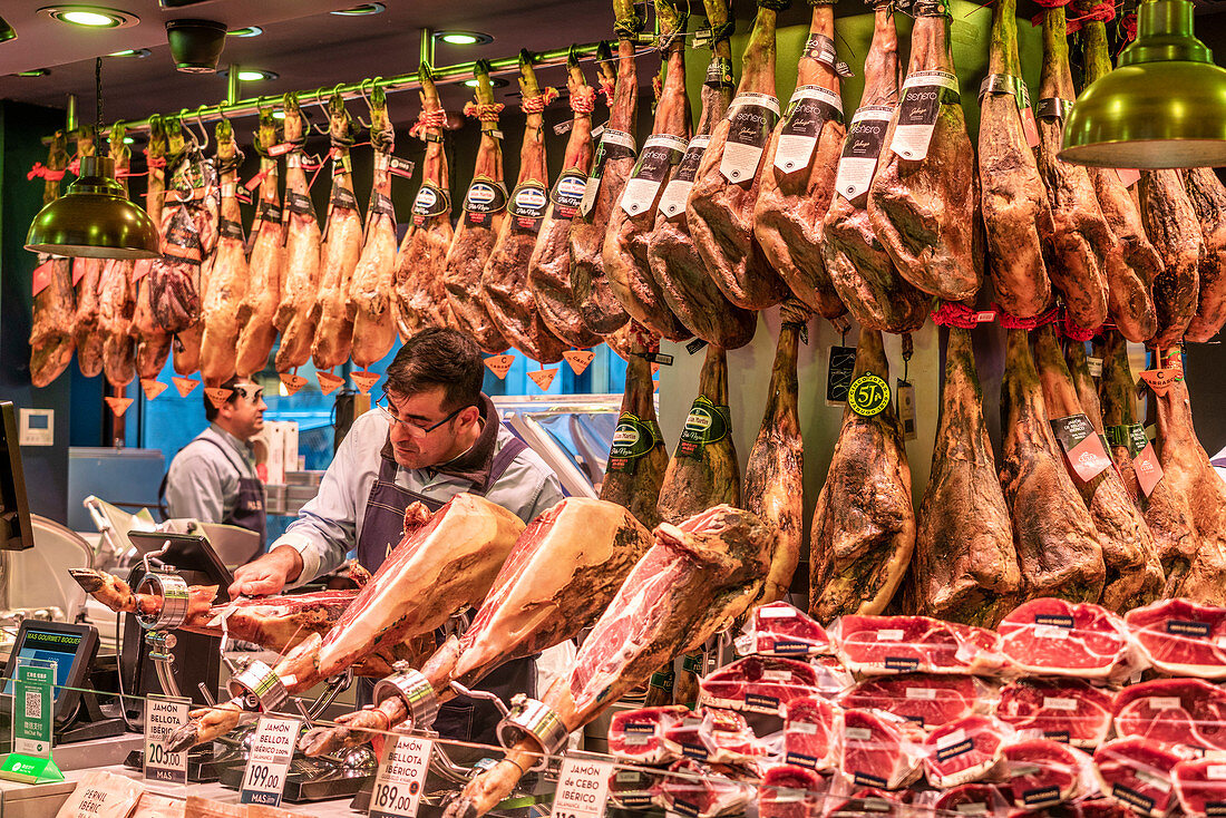 Mercat de la Boqueria, man cutting jamon serrano, ham stand, indoor market, Barcelona, Spain