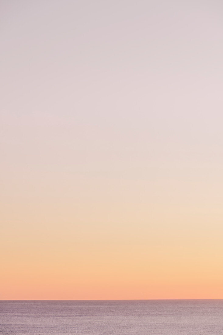 View of calm ocean waters, horizon and sky at dawn, northern Oregon coast