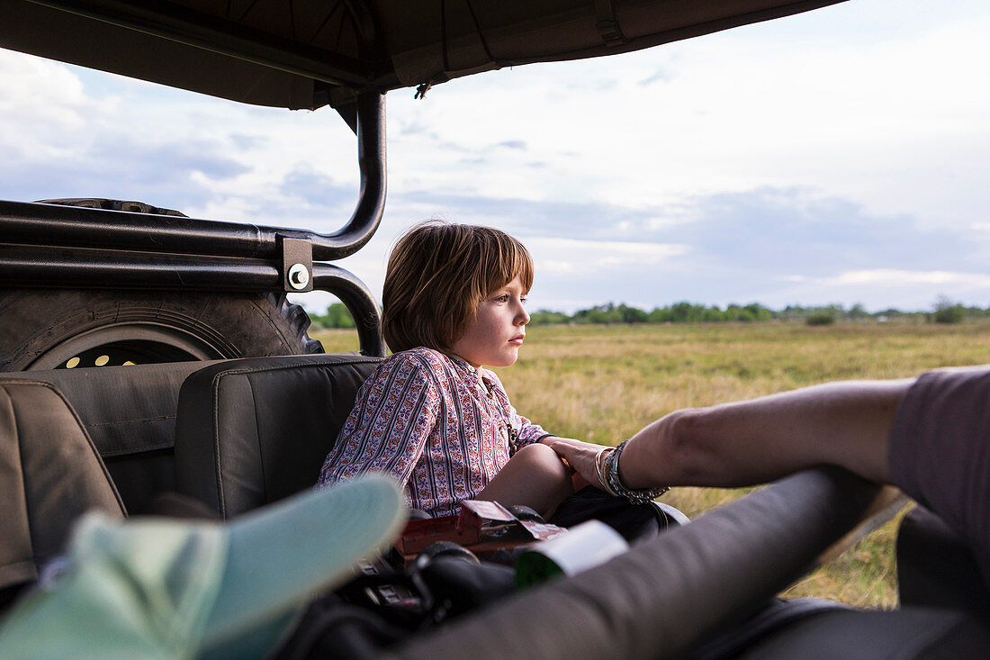 A five year old boy on safari, in a jeep in a game reserve