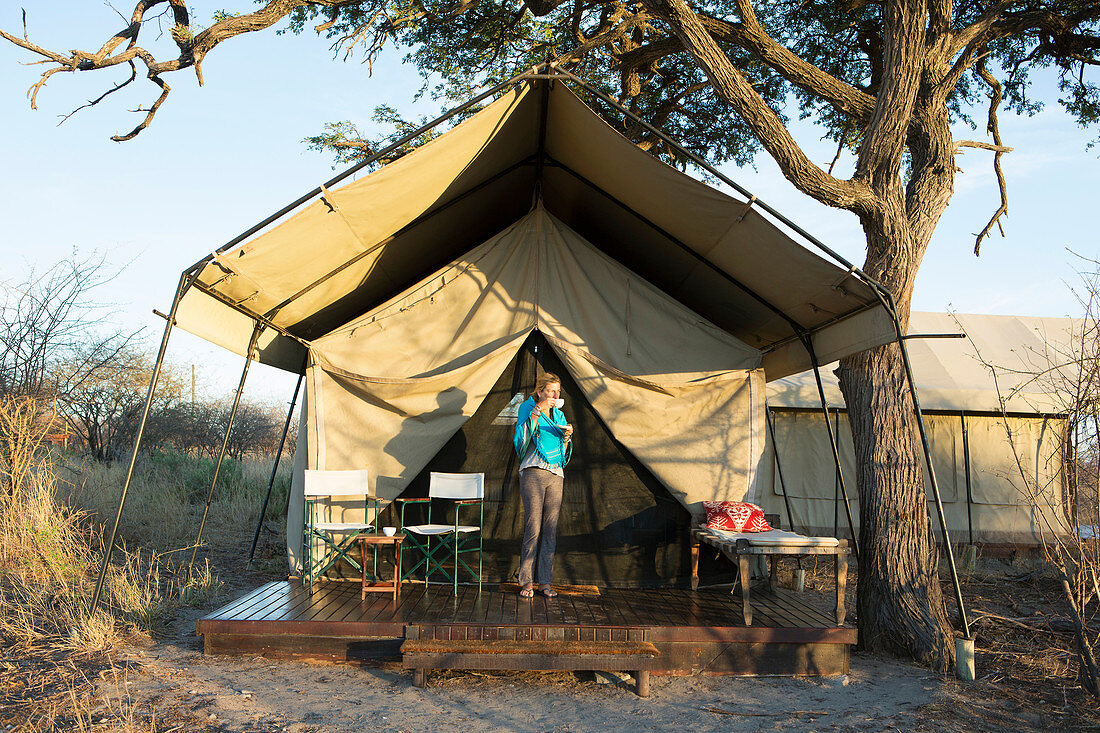 A young girl outside her tent at a wildlife reserve in the Kalahari Desert.