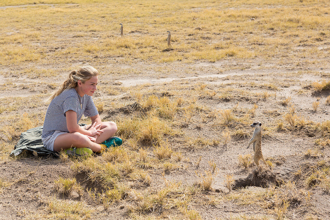 Zwölfjähriges Mädchen betrachtete Erdmännchen, Kalahari-Wüste, Makgadikgadi-Salzpfannen, Botswana
