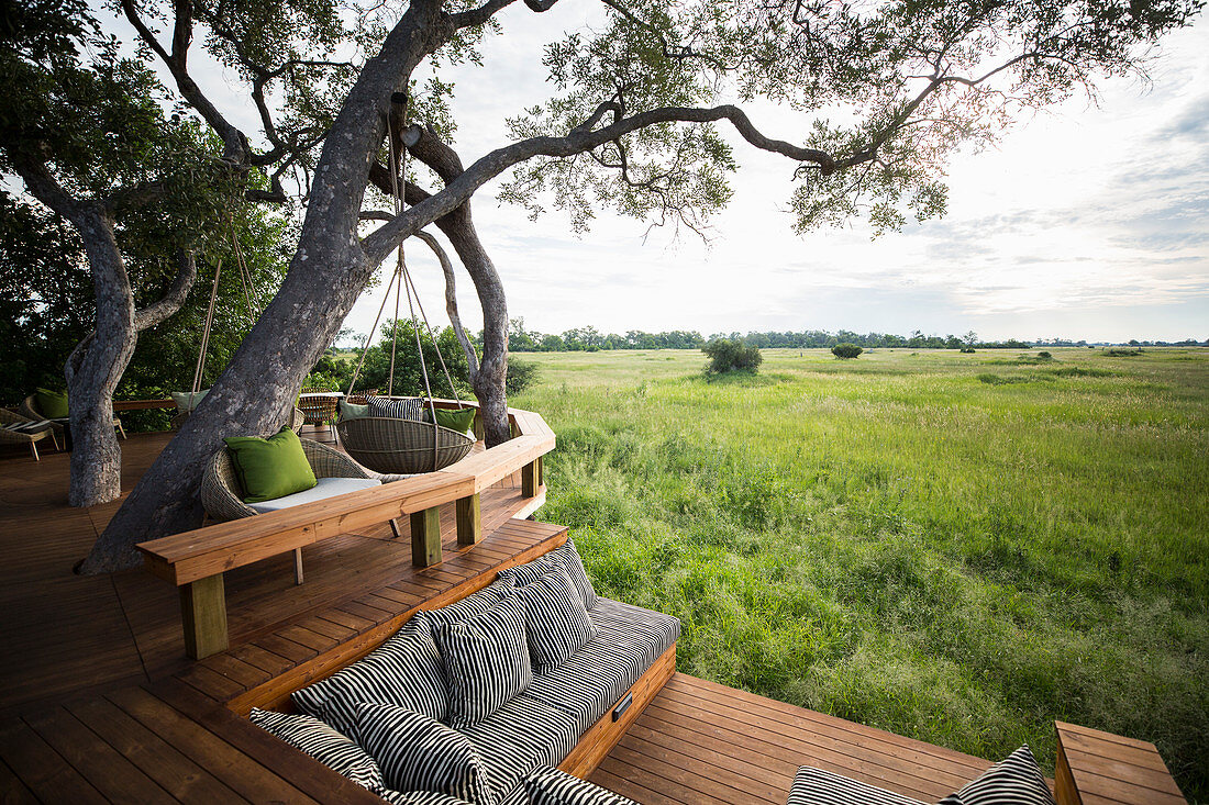 Wooden platform overlooking scenic landscape at a tented safari camp.