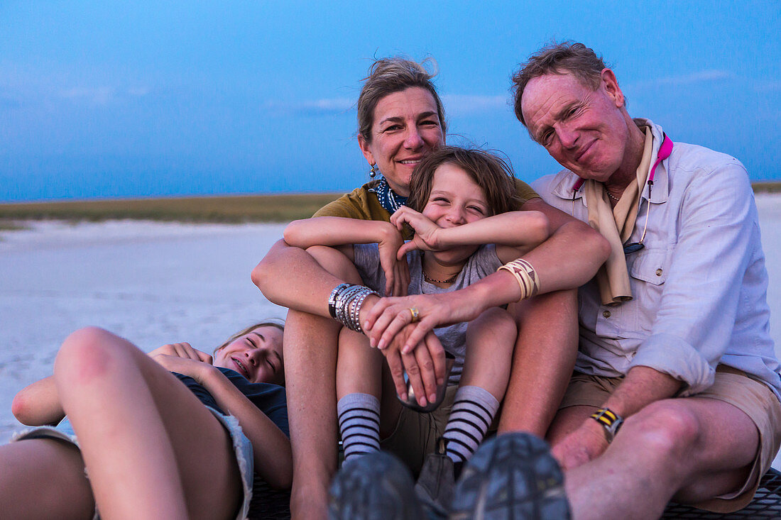 smiling family on top of safari vehicle, Nxai Pan, Botswana