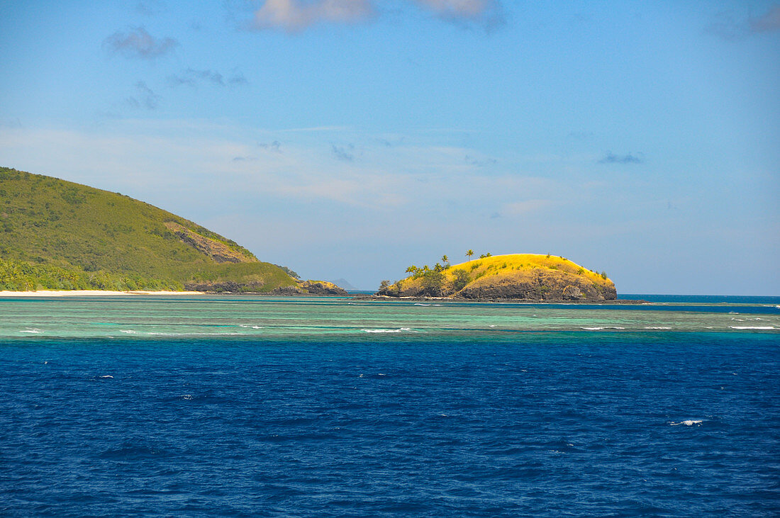 Blick auf das türkise Wasser mit Korallenriff und eine kleine Insel, Fiji Islands