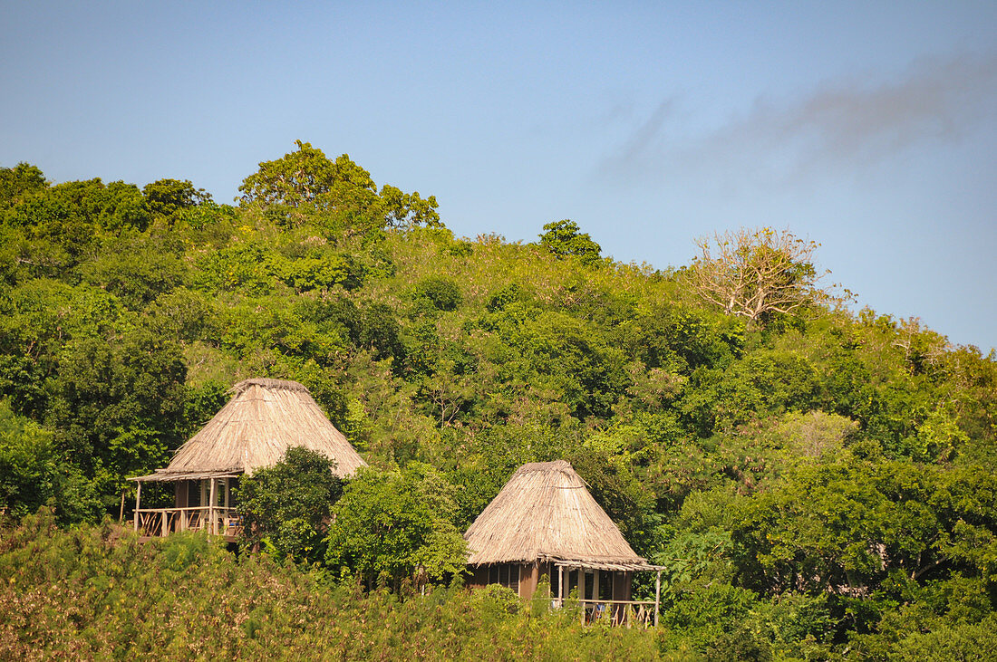 Small huts of a beach resort, surrounded by tropical vegetation, Fiji ISlands