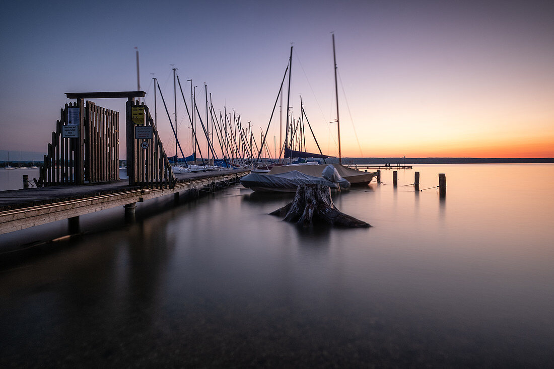 View of sailing boats on jetty on Lake Ammer at sunset, Bavaria, Germany, Europe