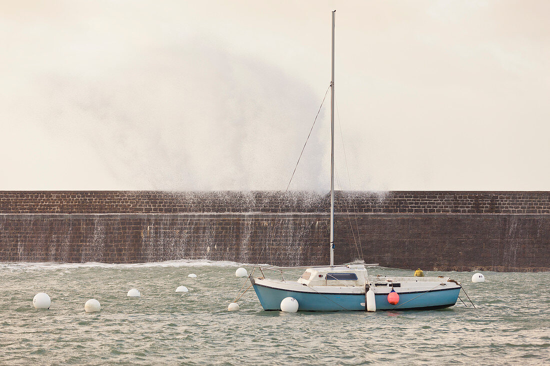 Boot hinter Hafenmauer im Sturm, Goury, Normandie, Frankreich