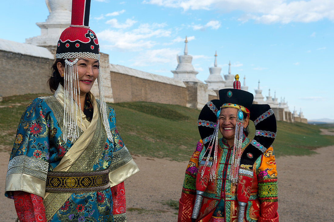 Mongolian women dressed in historic costume in front of the wall with stupas surrounding the Erdene Zuu monastery in Kharakhorum (Karakorum), a UNESCO World Heritage Site in Mongolia.