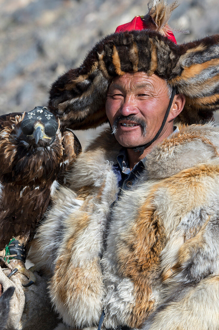 Porträt des kasachischen Adlerjägers Dalaikhan und seines Steinadlers in der Nähe der Stadt Ulgii (Ölgii) in der Provinz Bajan-Ölgii in der Westmongolei