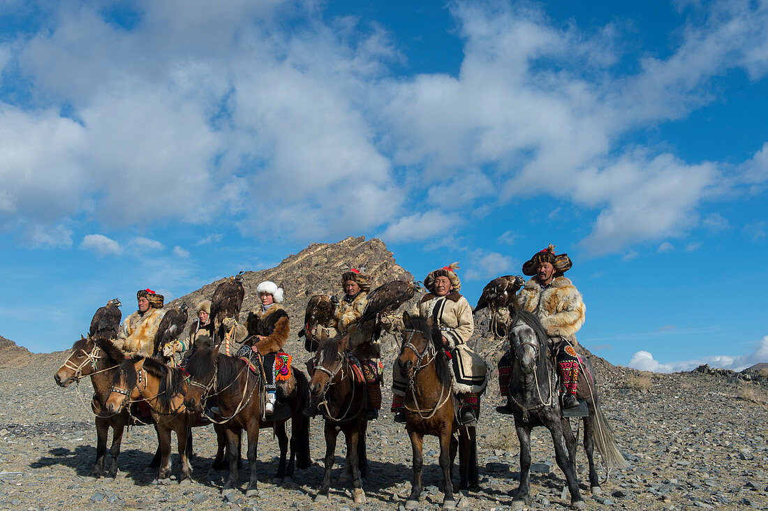 A group of Kazakh Eagle hunters and their Golden eagles on horseback on the way to the Golden Eagle Festival near the city of Ulgii (Ölgii) in the Bayan-Ulgii Province in western Mongolia.