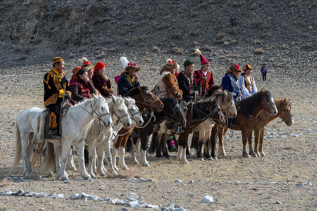 Die Teilnehmer der Kyz Kuar-Spielshow (Ein Mädchen einholen), die sich für das traditionelle Reitspiel anstellten, waren die Jungen, die von den Mädchen ausgepeitscht wurden, wenn das Mädchen den Jungen fangen kann. beim Golden Eagle Festival (Adlerjägerfest) in der Nähe der Stadt Ulgii (Ölgii) in der Provinz Bajan-Ölgii in der Westmongolei