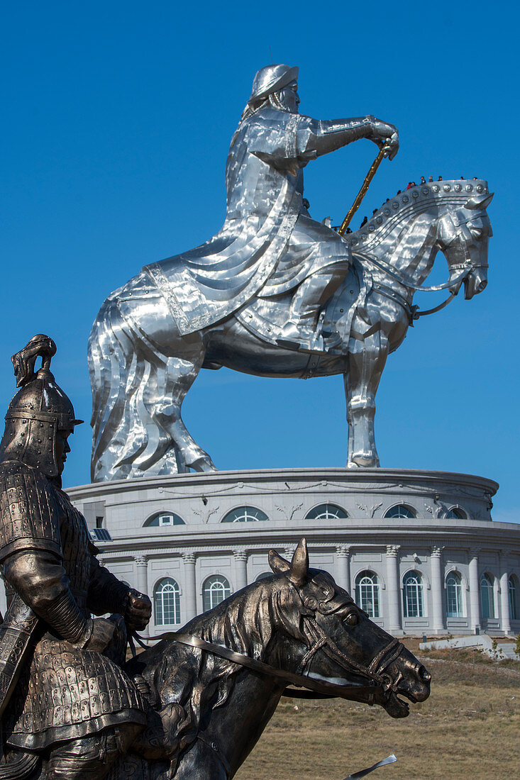 Nahaufnahme Reiters aus Bronze mit der Dschingis-Khan-Reiterstatue (130 Fuß hoch) im Hintergrund, Teile des Dschingis-Khan-Statuenkomplexes am Ufer des Tuul-Flusses bei Tsonjin Boldog, 33 Meilen östlich von Ulaanbaatar in der Mongolei