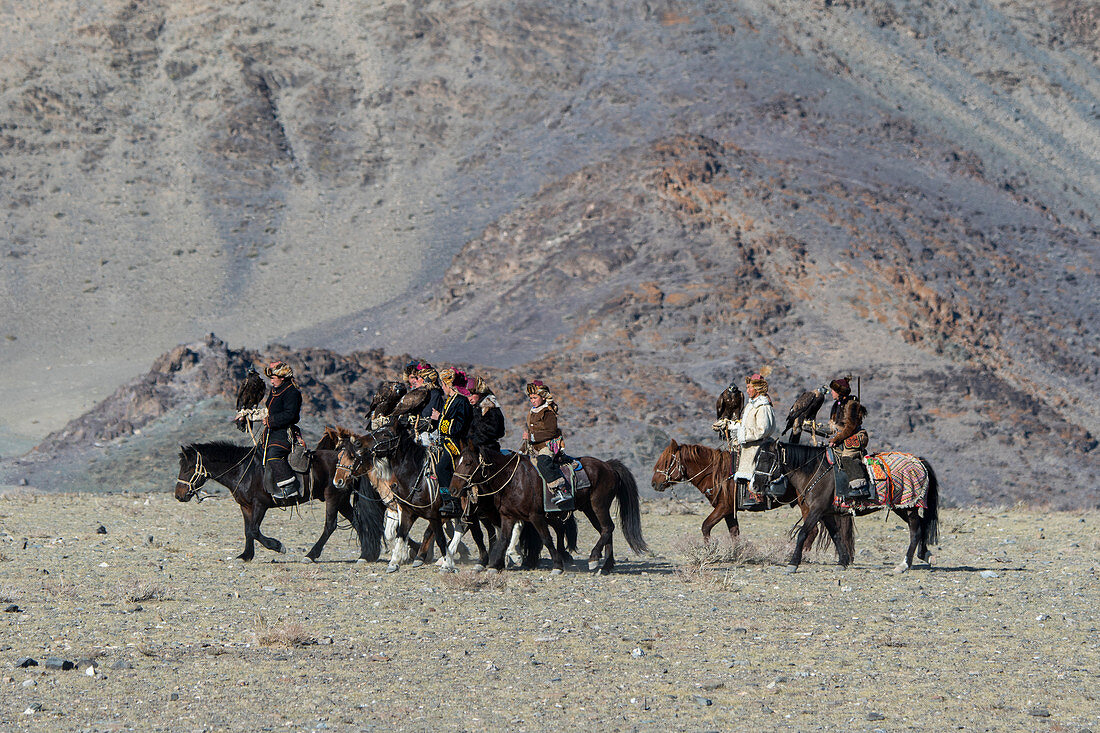 Eine Gruppe kasachischer Adlerjäger und ihre Steinadler treffen auf dem Gelände des Steinadlerfestivals ein, nahe der Stadt Ulgii (Ölgii) in der Provinz Bajan-Ulgii in der westlichen Mongolei