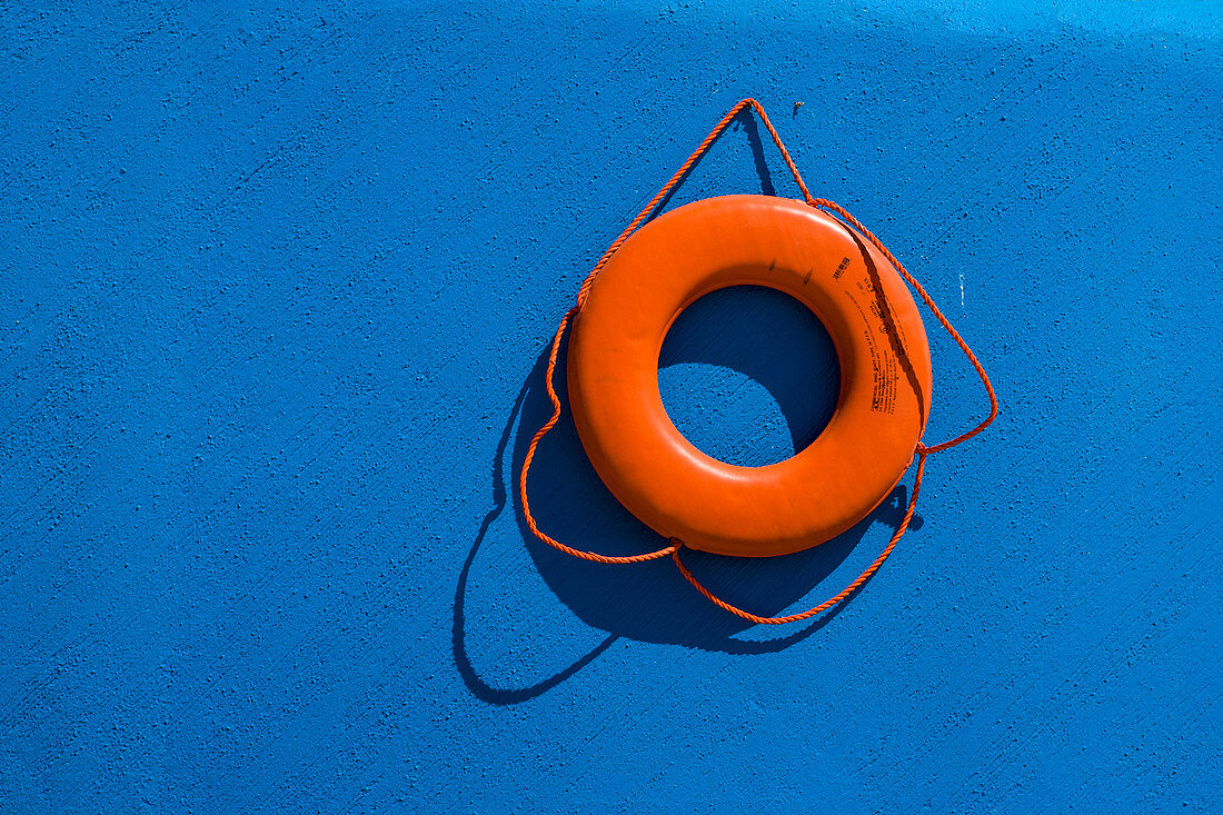 Red life preserver against blue wall