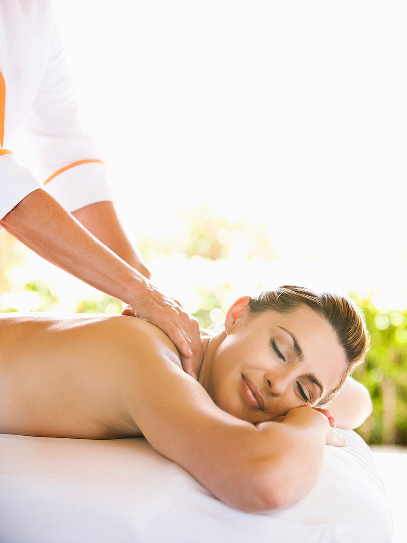 Smiling Woman with eyes closed receiving massage therapy at a luxury resort and spa in Napa Valley California