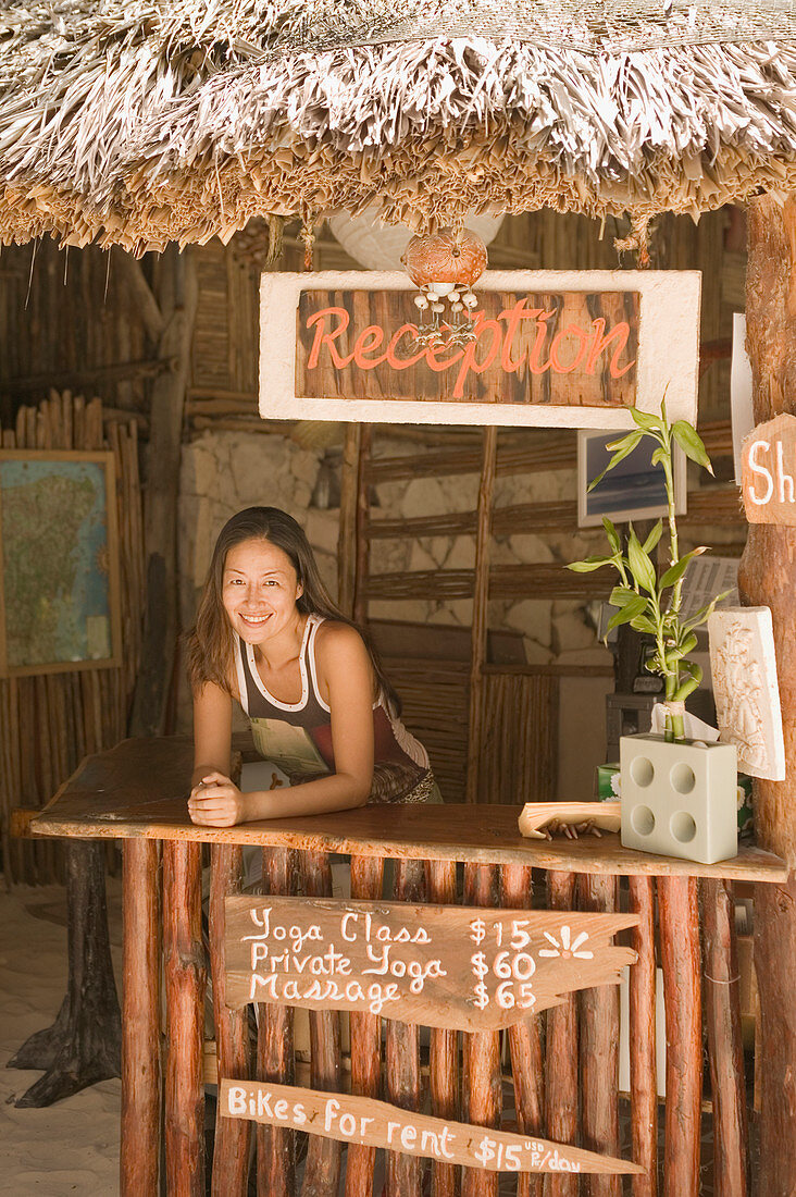 Young woman working at a beach reception desk