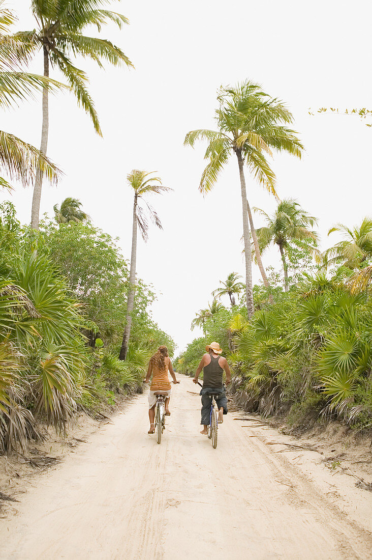 Paar fährt Fahrrad auf Sandweg