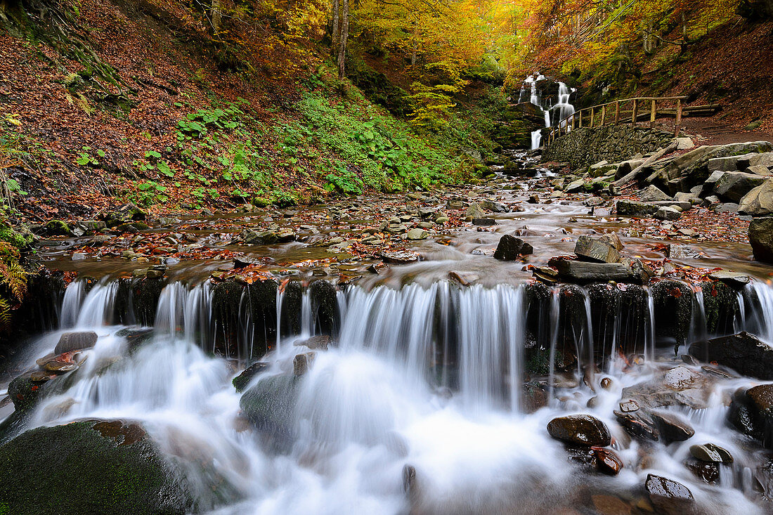 Ukraine, Region Transkarpatien, Karpaten, Werchnij Schepit Wasserfall, verschwommener Wasserfall im Herbstwald