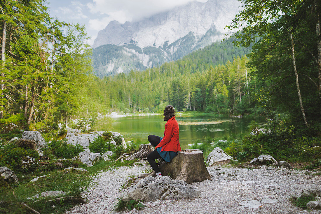 Germany, Bavaria, Eibsee, Woman sitting by?Frillensee?lake