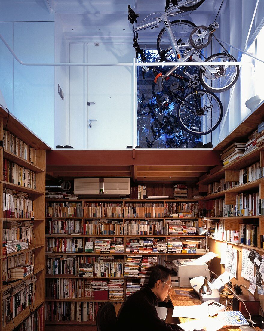 A study corner in an open room with a view of a gallery and parked bicycles