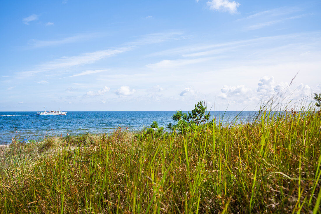 Blick über eine Düne mit einem weißen Schiff auf der Ostsee blauer Sommerhimmel, Usedom, Mecklenburg-Vorpommern, Deutschland