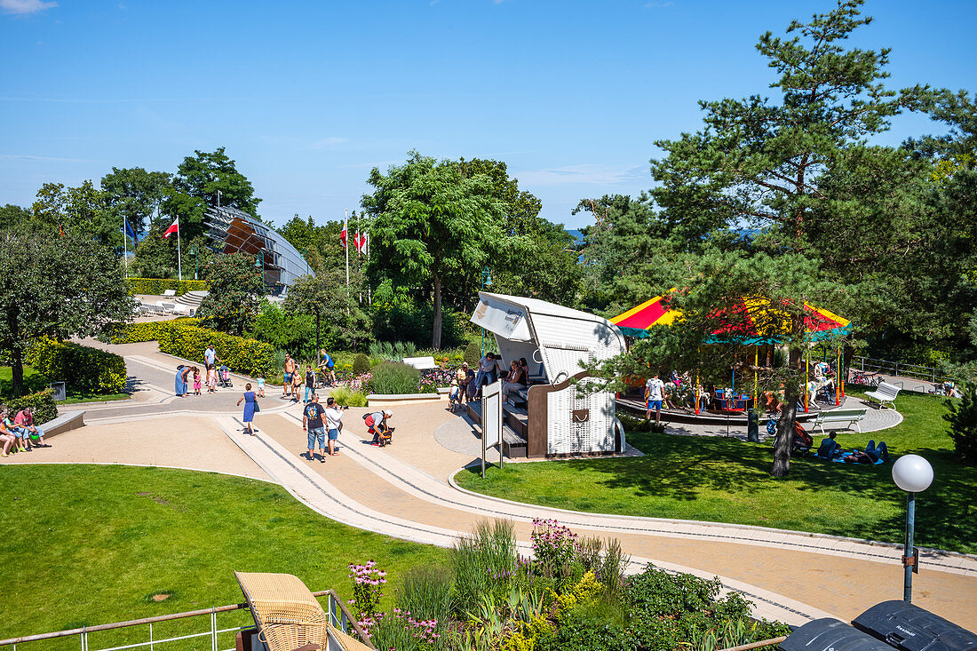 Promenade in Heringsdorf with an oversized beach chair, green spaces vacationers and tourists, Usedom, Mecklenburg-Western Pomerania, Germany