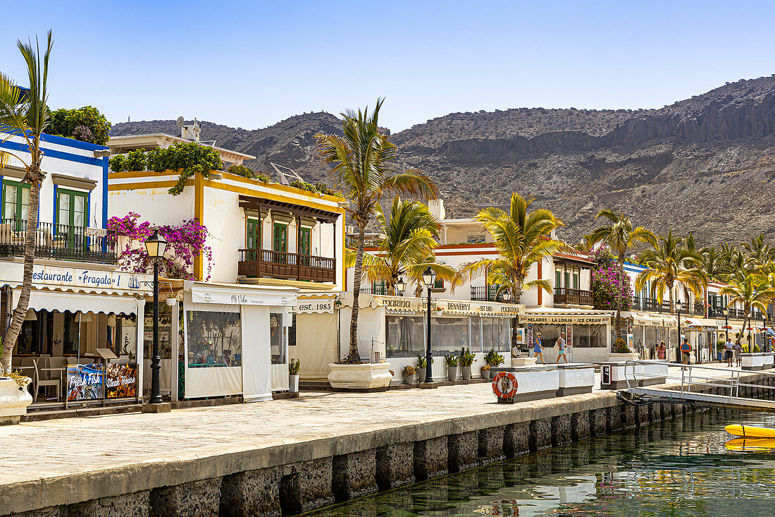 Promenade mit restaurierten bunten Häusern am Hafen von Puerto de Mogan, Südwesten von Gran Canaria, Spanien