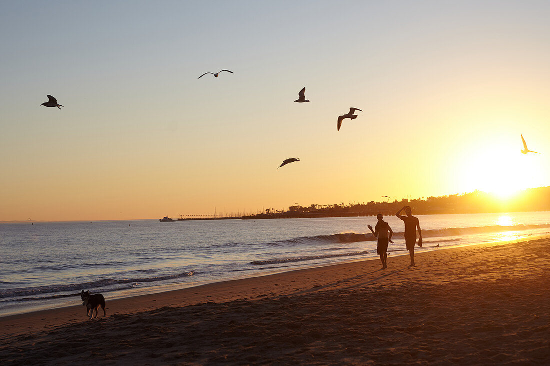 Strollers in sunset on Santa Barbara Beach, California, USA.