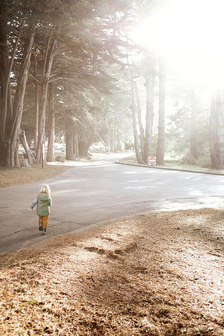 Child runs down a street near Big Sur, California, USA.