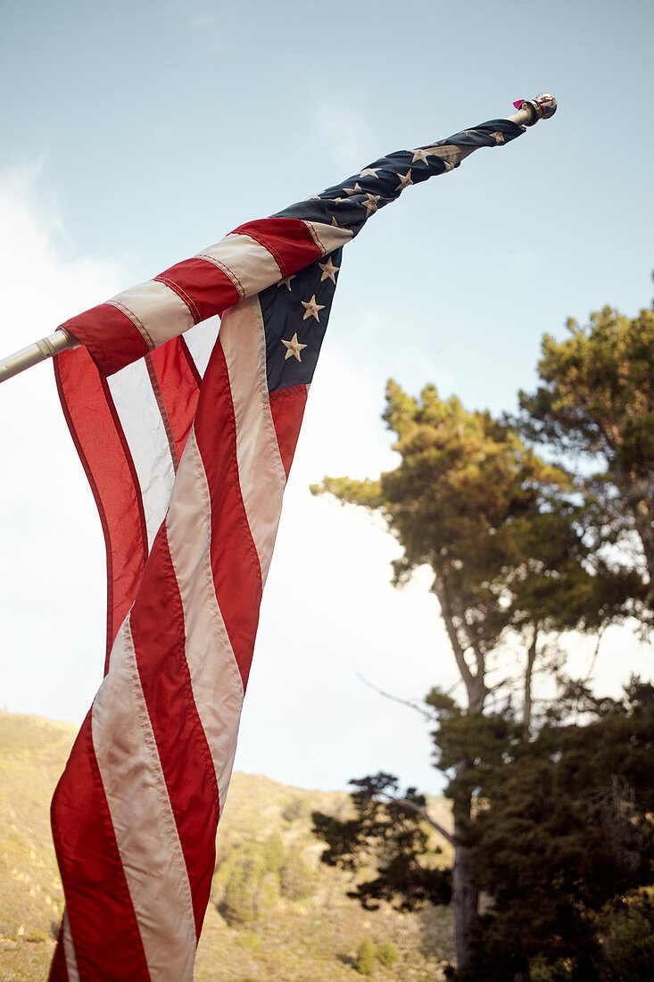 American flag in the evening light in a parking lot near Big Sur on Highway 1, California, USA.