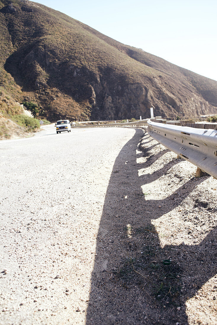 Kleines Auto fährt auf dem Highway 1 in Höhe von Big Sur State Park, Kalifornien, USA.