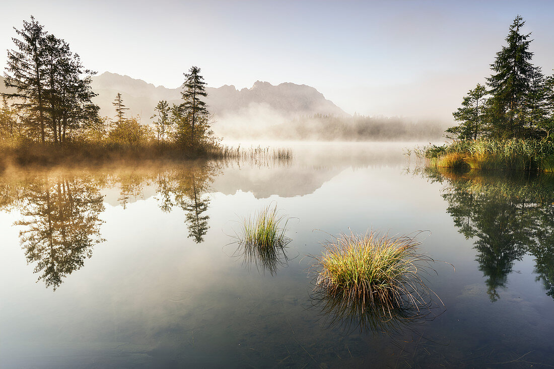 Sunrise at the Barmsee with a view towards the Karwendel massif, Bavaria, Germany.