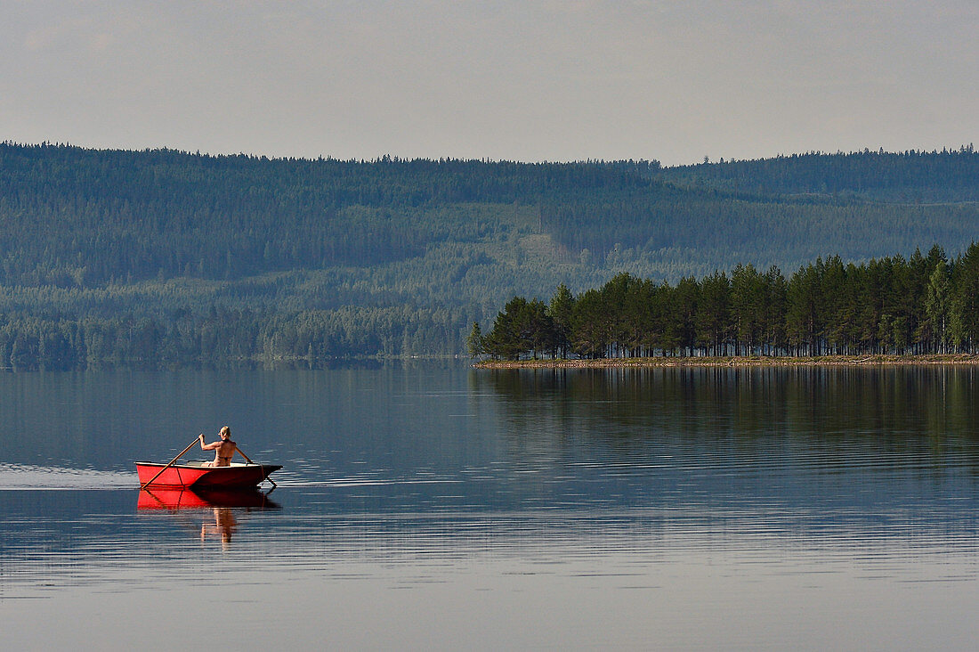 Junge Frau in einem Ruderboot, Orsjön, Tomterna, Västernorrbotten, Schweden