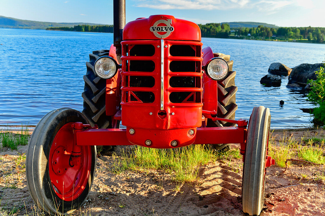 Ein uralter roter Traktor am See, Volvo, Orsjön, Tomterna, Västernorrland, Schweden