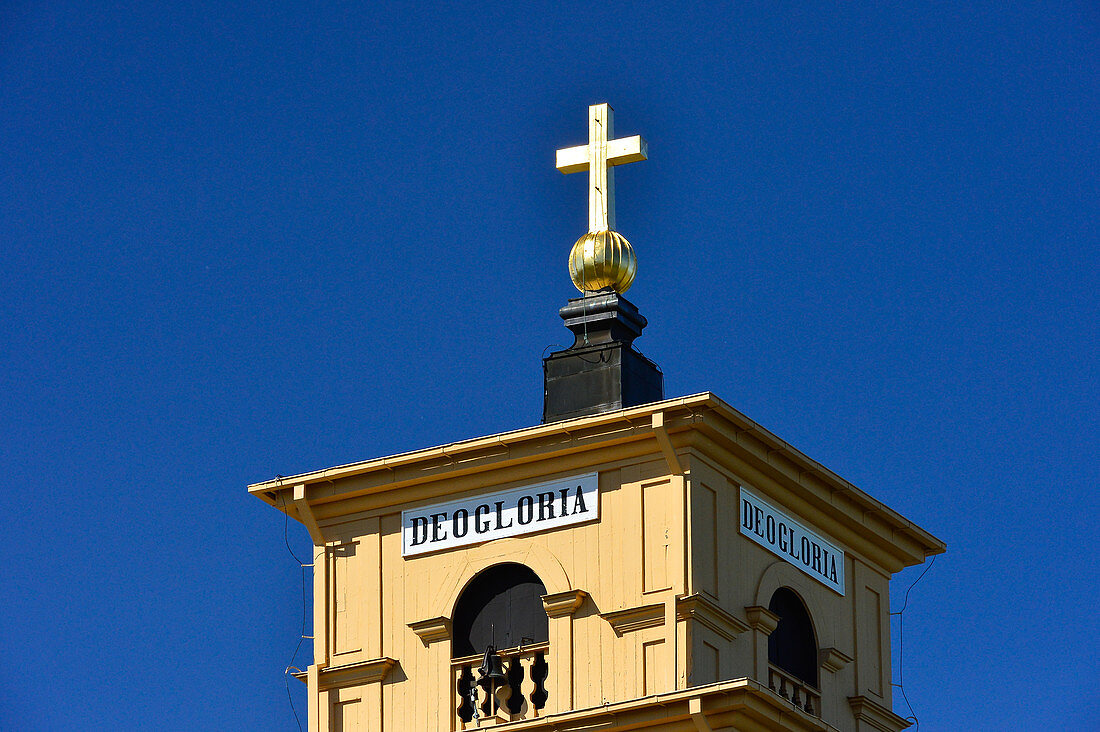 Kirchturmspitze mit golden leuchtendem Kreuz vor blauem Himmel, Gammelstad, Luleå, Norrbottens Län, Schweden