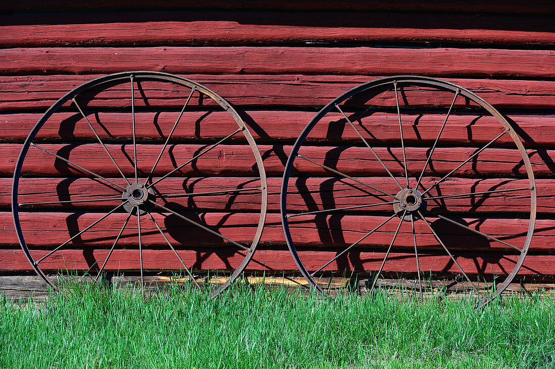 Zwei Metallräder lehnen an einer roten Holzhütte, Hundsjön, bei Boden, Norrbottens Län, Schweden