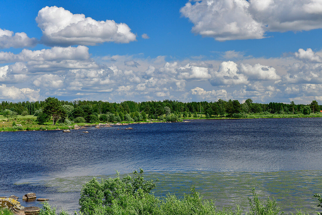 Ein großer See mit bewaldetem Ufer und schönem Wolkenbild, bei Fors, Dalarna, Schweden