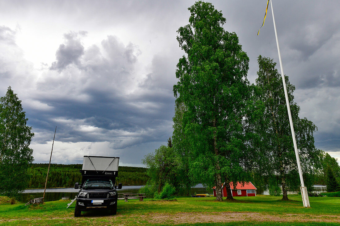 Pickup-Camper bei einem Gemeindehaus am See in Gänsen, Provinz Örebro, Schweden