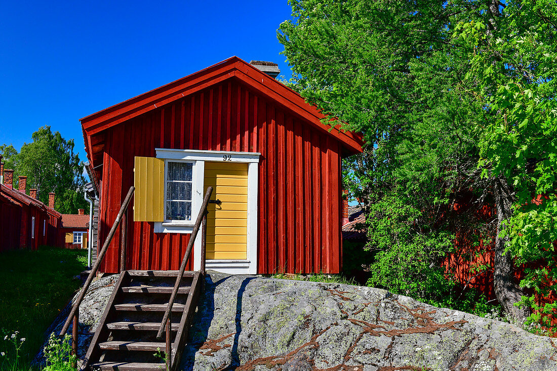 Traditionelle rote Holzhütte mit Treppe auf einem Felsen, Lövanger Kyrkstad, Västerbottens Län, Schwden