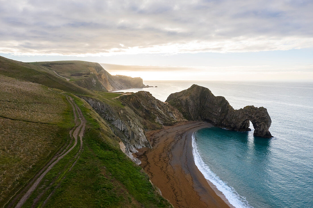 Aerial view at sunrise of the Durdle Door, a natural limestone arch on the Jurassic Coast near Lulworth in Dorset, Southern England. 
