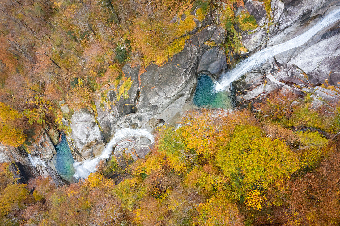 Luftaufnahme von dem Wasserfall des Flusses Valegg da Cansgell im Herbst nahe der Stadt Lavertezzo, Verzascatal, Kanton Tessin, Schweiz