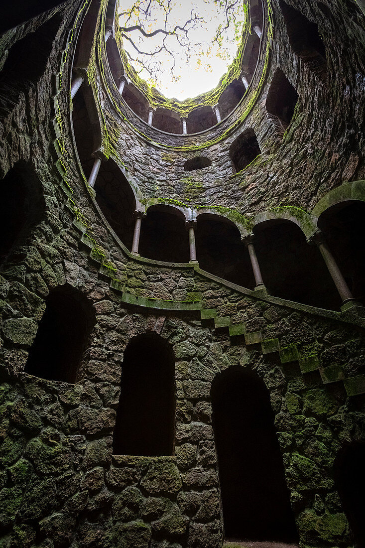View from below of the spiral stairs inside the inverted tower, called also initiation well, at Quinta da Regaleira Palace, Sintra, Portugal, Europe.