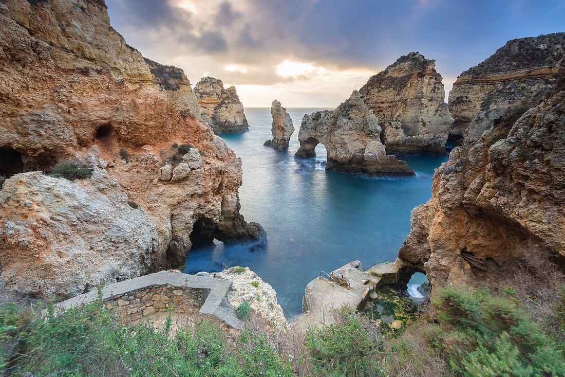 Cloudy sunrise at the yellow and red cliffs of Ponta da Piedade. Lagos, Algarve, Portugal, Europe.